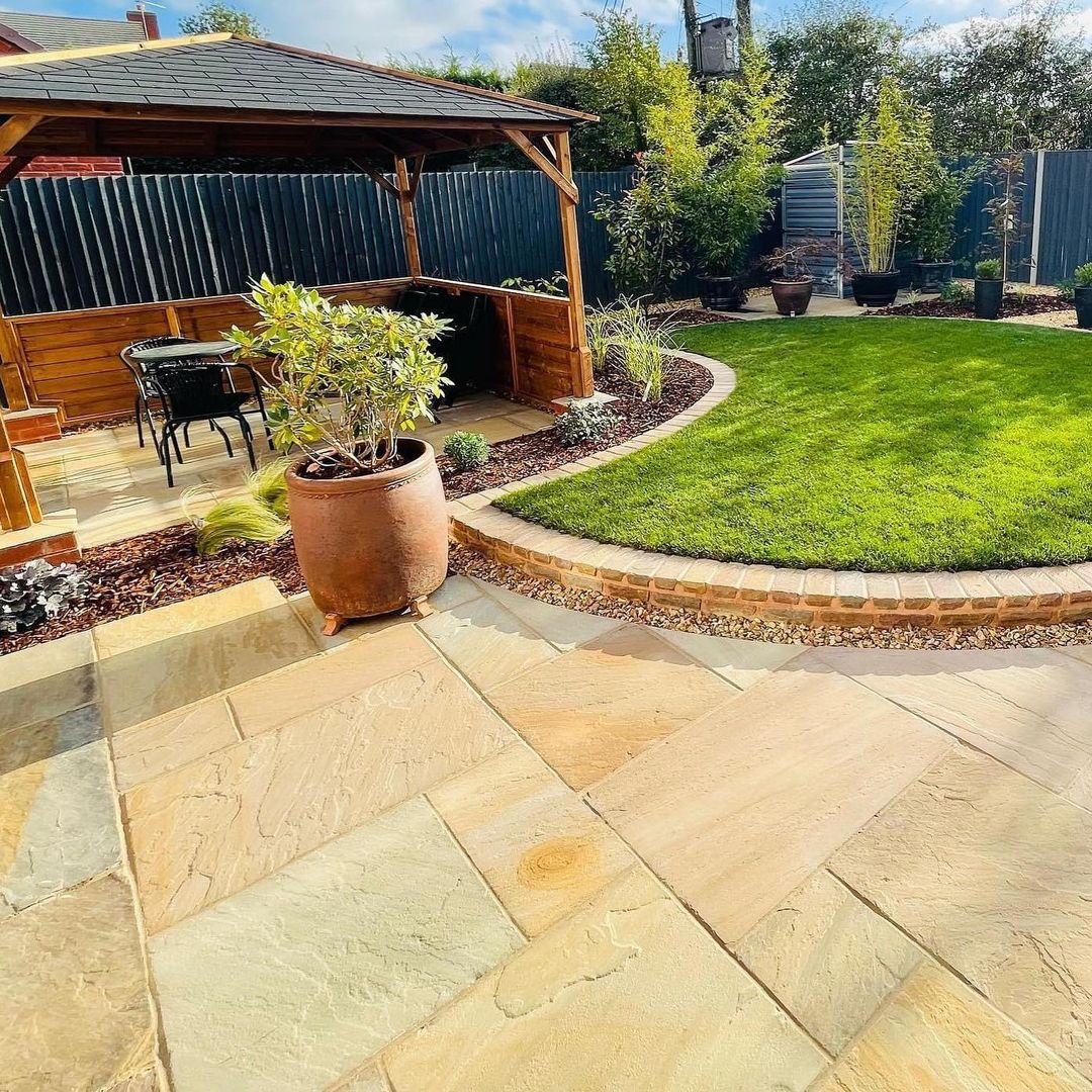 Sandstone patio and curved lawn landscaped by Lita Paving & Patios