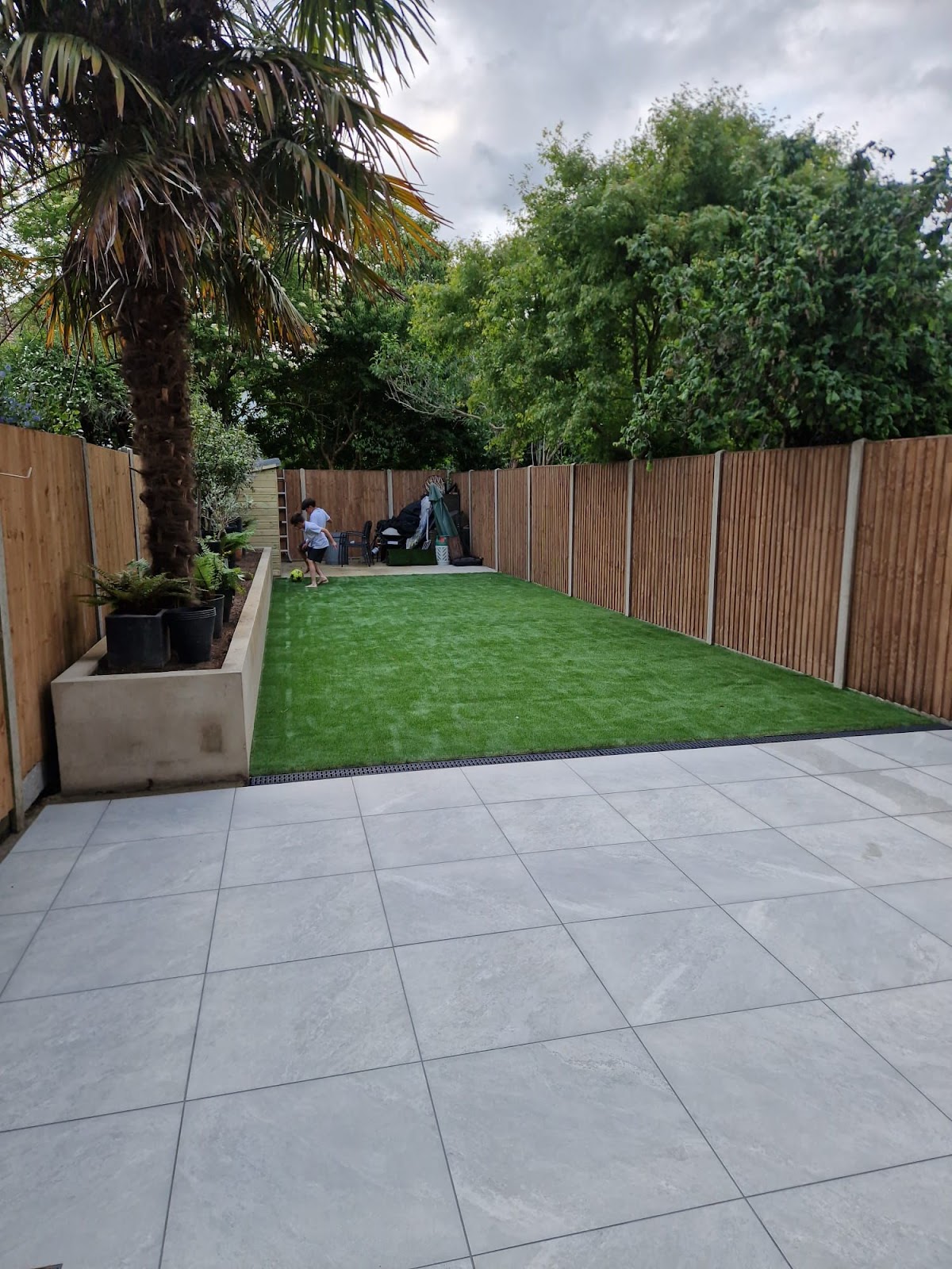 Garden after landscaping by Lita — new artificial lawn, porcelain patio and fencing